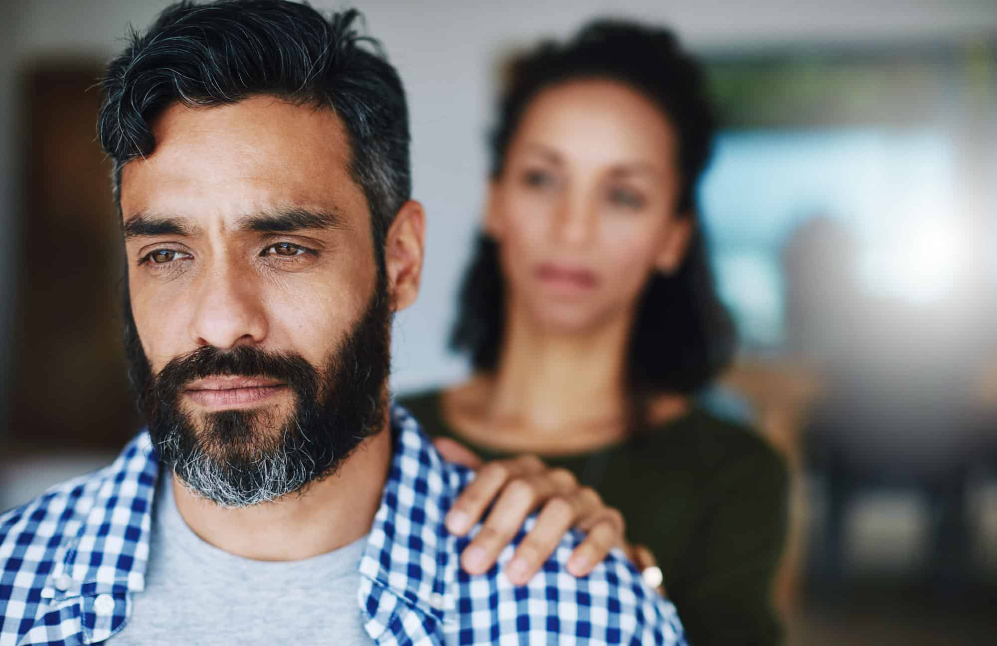 Dont keep it all bottled up. Shot of a woman comforting her distraught husband at home